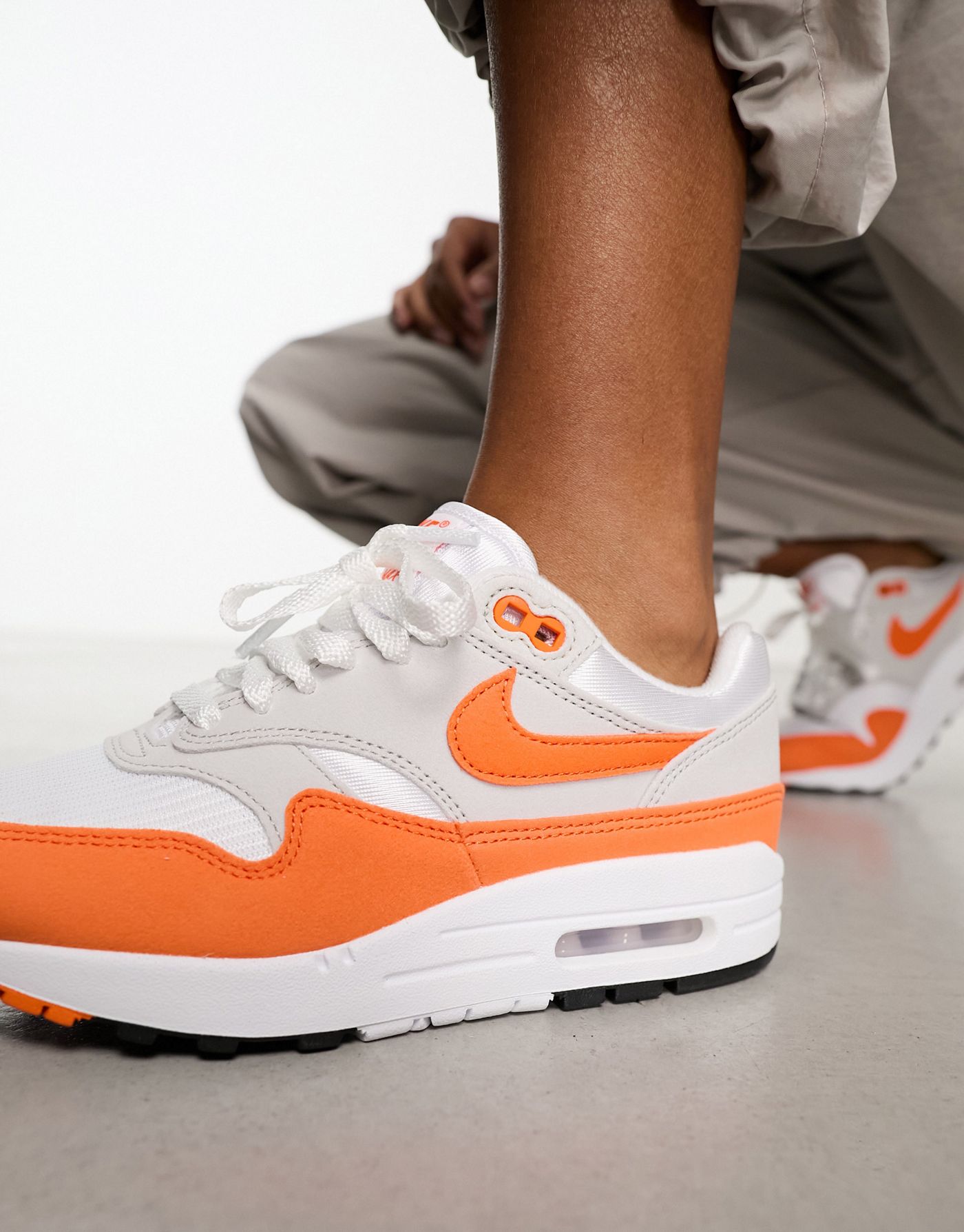Nike Air Max 1 trainers in grey and safety orange