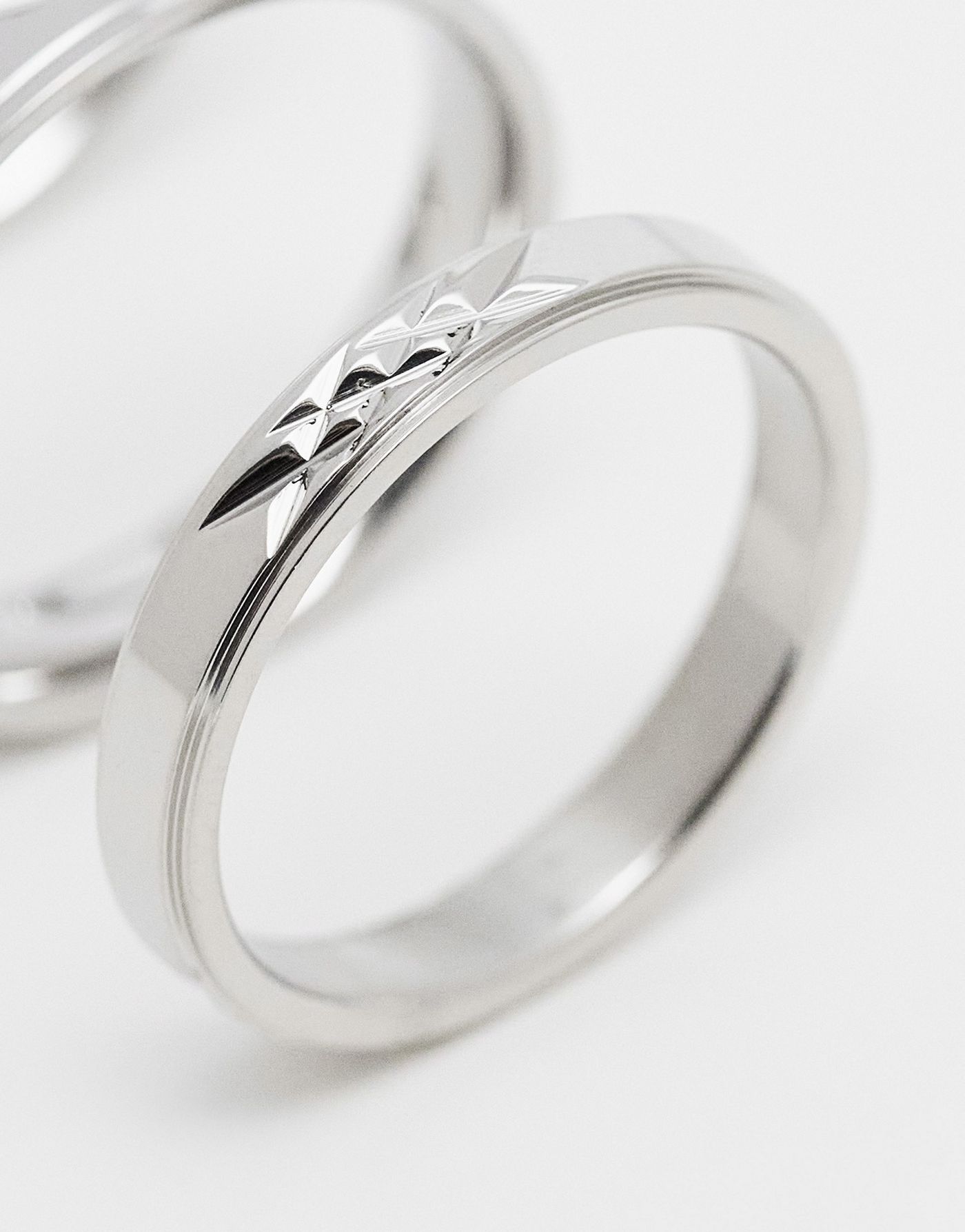 ASOS DESIGN 4 pack waterproof stainless steel skinny band ring set with embossing detail in silver tone